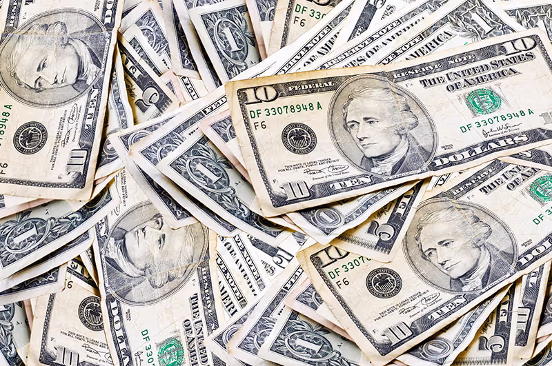 Medium pile of money symbolizing mid-ticket coaching models, offering a balance between affordability and profitability with multi-session packages, online courses, and workshops